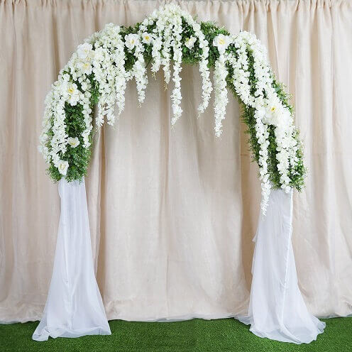 Wonderful Wedding Arch Décor Using Grass Rug, Metal Arch, Wisteria Vine Garlands & White Fabric