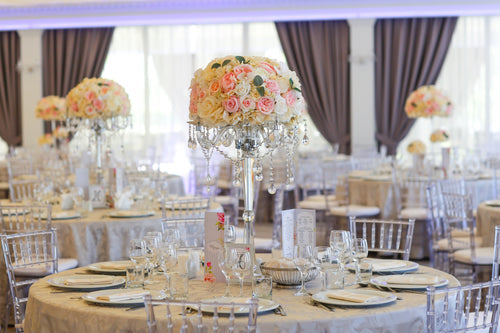 Banquet table with tablecloth and glass flower vase